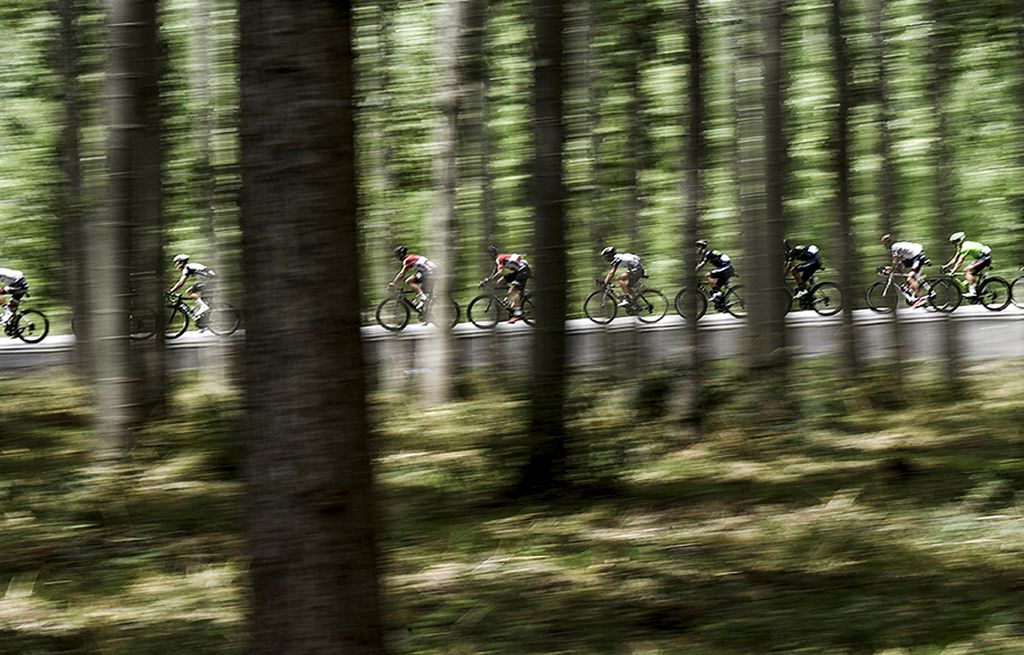 Iring-iringan   pebalap melintasi kawasan hutan di etape ke-11 kejuaraan balap sepeda Tour de France 2017, yang melintasi Eymet hingga Pau, Perancis, Rabu (12/7). 