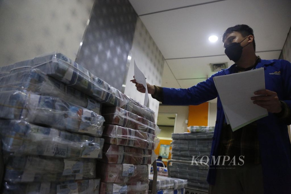 Petugas menyiapkan uang di tempat penyimpanan uang Bank Mandiri di Plaza Mandiri, Jakarta, Selasa (7/3/2023).