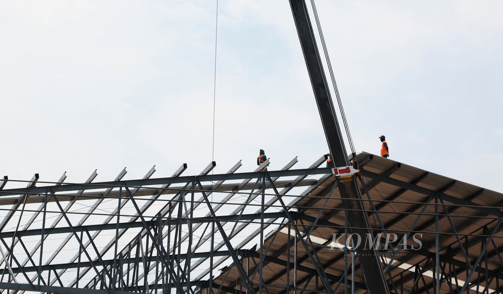 Pekerja berada di antara konstruksi baja pada proyek pembangunan sebuah pabrik manufaktur di Kecamatan Sayung, Kabupaten Demak, Jawa Tengah, Senin (24/10/2022). Sepanjang kawasan pesisir utara jawa di Jawa Tengah ini tumbuh menjadi kawasan industri seiring dengan kemudahan akses bagi investor. 