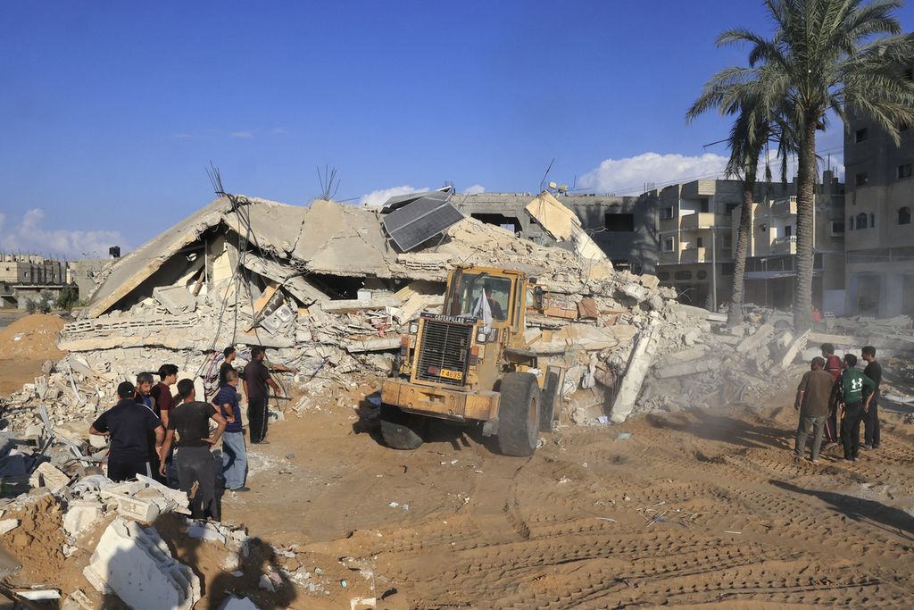 Kendaraan berat membersihkan puing-puing rumah keluarga Duheir yang hancur karena serangan udara Israel di Rafah, sebelah selatan Jalur Gaza, 19 Oktober 2023. 