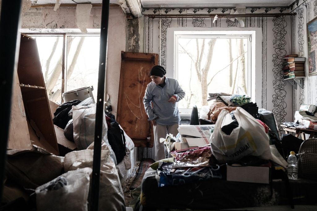 A woman cleans a room at an apartment damaged by a missile explosion in Kramatorsk, eastern Ukraine, on May 5, 2022, amid the Russian invasion of Ukraine. 