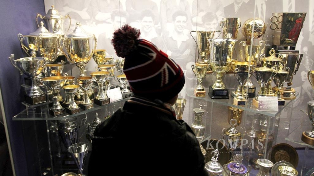 Pengunjung melihat koleksi piala yang pernah dimenangi Manchester United ketika mengikuti tur di museum Stadion Old Trafford, Manchester, Inggris, Rabu (27/12/2017). MU adalah salah satu klub tersukses di Inggris. 