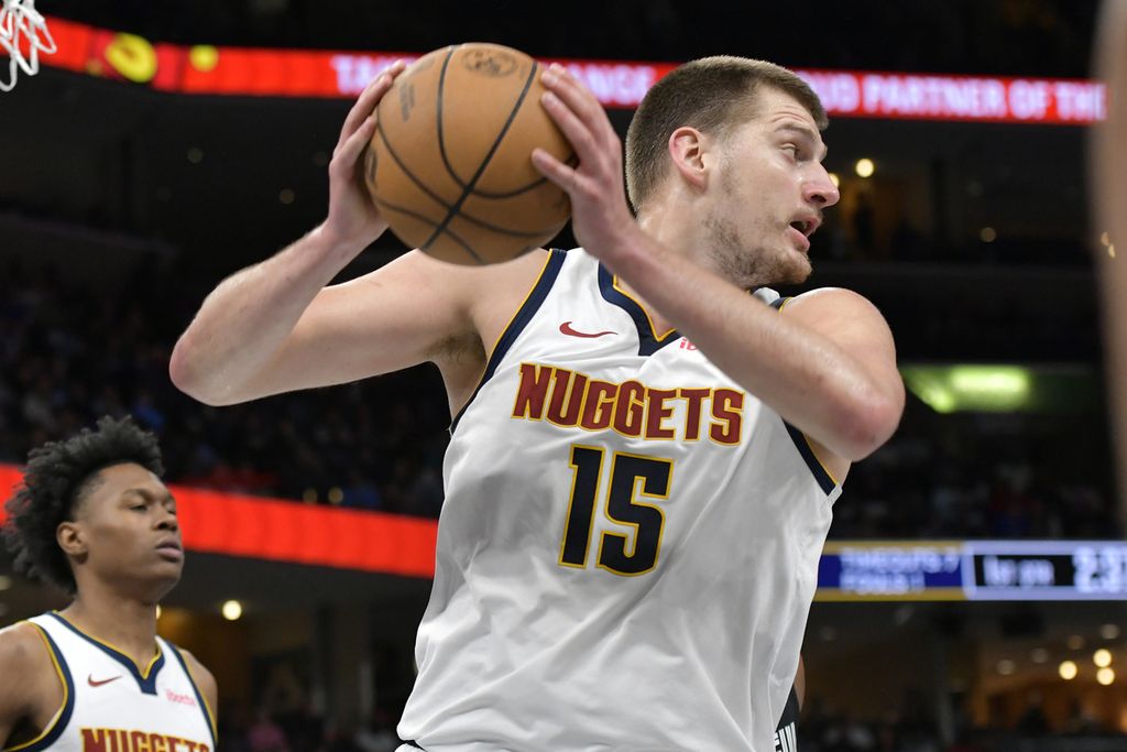 Denver Nuggets basketball player, Nikola Jokic, holds the ball in an NBA game between Memphis Grizzlies and Nuggets in Memphis, Tennessee, on Monday (15/4/2024).