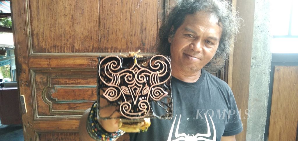 Agus Riyanto (55) bersama cap batik berbentuk kepala banteng di Kota Batu, Jawa Timur, Rabu (12/1/2022).
