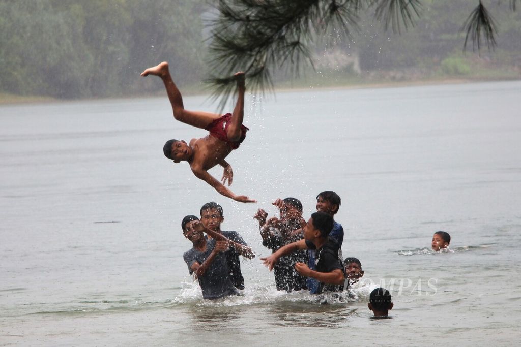 Anak-anak mengisi waktu libur akhir pekan dengan bermain di sungai di Desa Meunasah Lambaro, Kecamatan Lhoknga, Kabupaten Aceh Besar, Aceh, Minggu (30/7/2023). Objek wisata alam kini menjadi pilihan utama bagi warga untuk mengisi hari libur.