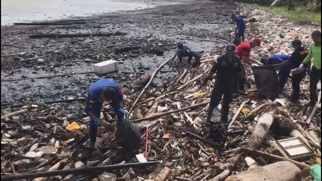 Petugas gabungan membersihkan Pantai Sakera, Bintan, Kepulauan Riau, dari cemaran limbah minyak hitam, Kamis (14/3/2024). 