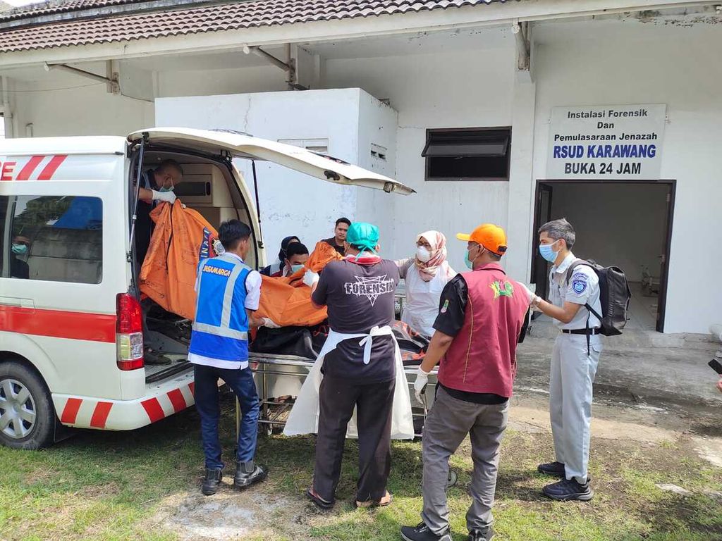 Petugas kesehatan dan polisi mengevakuasi korban kecelakaan di Kilometer  58 Tol Jakarta-Cikampek di RSUD Karawang, Senin (8/4/2024). Sebanyak 12 orang tewas dalam kejadian ini.