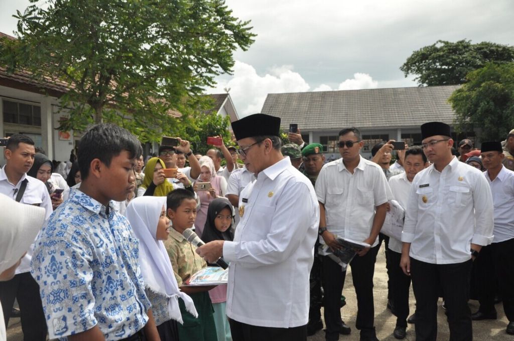 Gubernur Banten Wahidin Halim memberikan bantuan kepada para pelajar yang terkena dampak tsunami di Pandeglang, Banten, 16 Januari 2019. 
