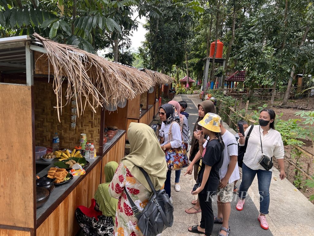 Wisatawan berbelanja di lapak-lapak milik warga yang berjualan kuliner tradisional di Pasar Pancingan Desa Wisata Hijau Bilebante, Kecamatan Pringgarata, Kabupaten Lombok Tengah, Nusa Tenggara Barat, Minggu (17/7/2022). 