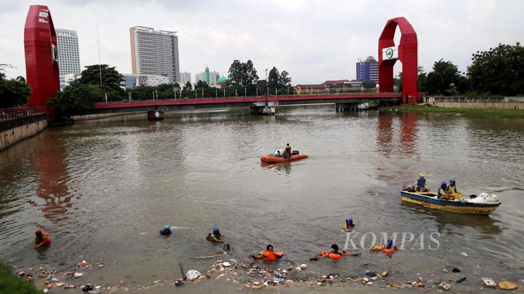 Petugas Dinas Pekerjaan Umum dan Penataan Ruang Kota Tangerang mengumpulkan sampah yang mengambang di Sungai Cisadane, yang membelah Kota Tangerang, Banten, Kamis (31/1/2019). Setiap hari mereka membersihkan sampah yang terbawa dari arah hulu itu.