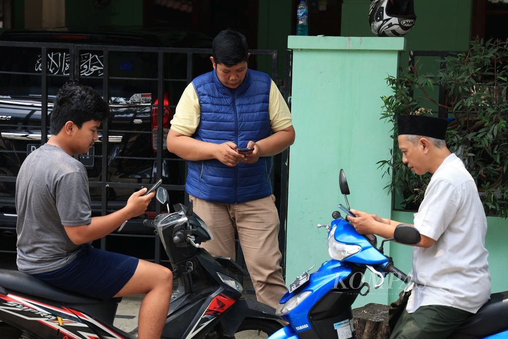 Warga memanfatkan ponselnya untuk bertransaksi elektronik dan kebutuhan lainnya di kawasan Pamulang, Tangerang Selatan, Banten, Minggu (11/9/2022). 