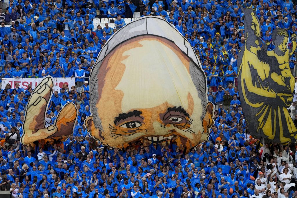 Gambar wajah Paus Fransiskus dibentangkan di Stadion Velodrome, Marseille, Perancis, Sabtu (23/9/2023). Di stadion itu, Paus antara lain membahas soal isu pengungsi. 