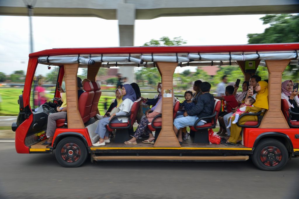 Warga menggunakan bus antar-jemput di Taman Mini Indonesia Indah, Jakarta Timur, Minggu (1/1/2023). 