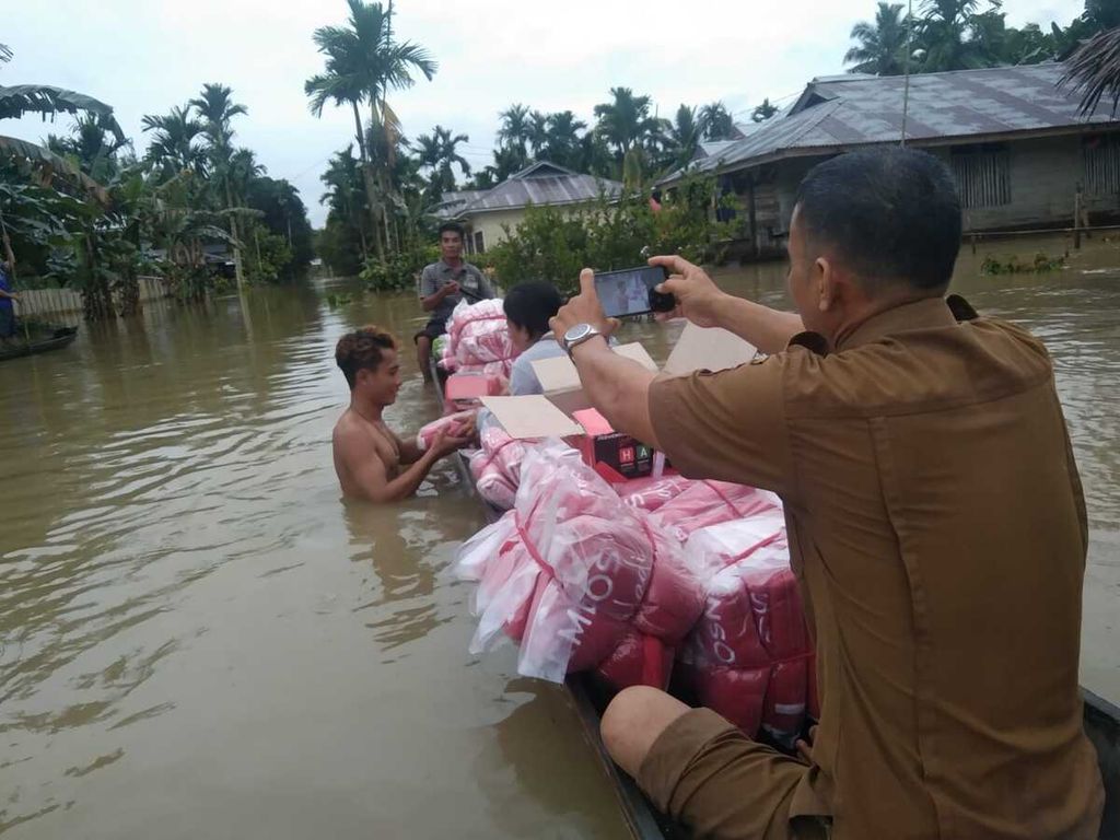 Petugas menyerahkan bantuan logistik dari lumbung sosial kepada warga terdampak banjir di Desa Mongan Poula, Kecamatan Siberut Utara, Kepulauan Mentawai, Sumatera Barat, Senin (14/11/2022).