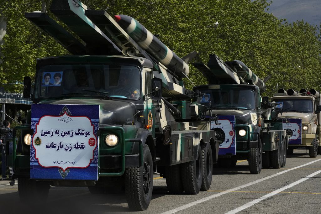 Rudal dibawa dengan truk saat parade Hari Tentara di pangkalan militer di Teheran, Iran, pada 17 April 2024. Dalam parade tersebut, Presiden Ebrahim Raisi memperingatkan, ”invasi terkecil” oleh Israel akan membawa dampak yang besar. 