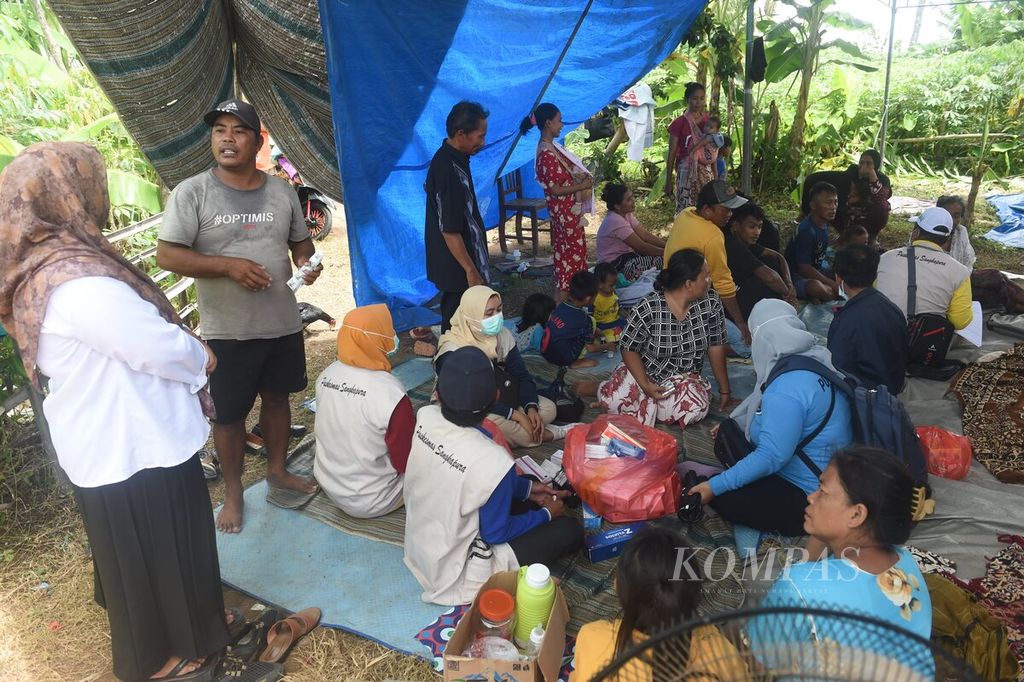 Tenaga kesehatan Puskesmas Sangkapura memeriksa kesehatan warga di pengungsian korban gempa Desa Dekatagung, Kecamatan Sangkapura di Pulau Bawean, Gresik, Selasa (26/3/2024). 