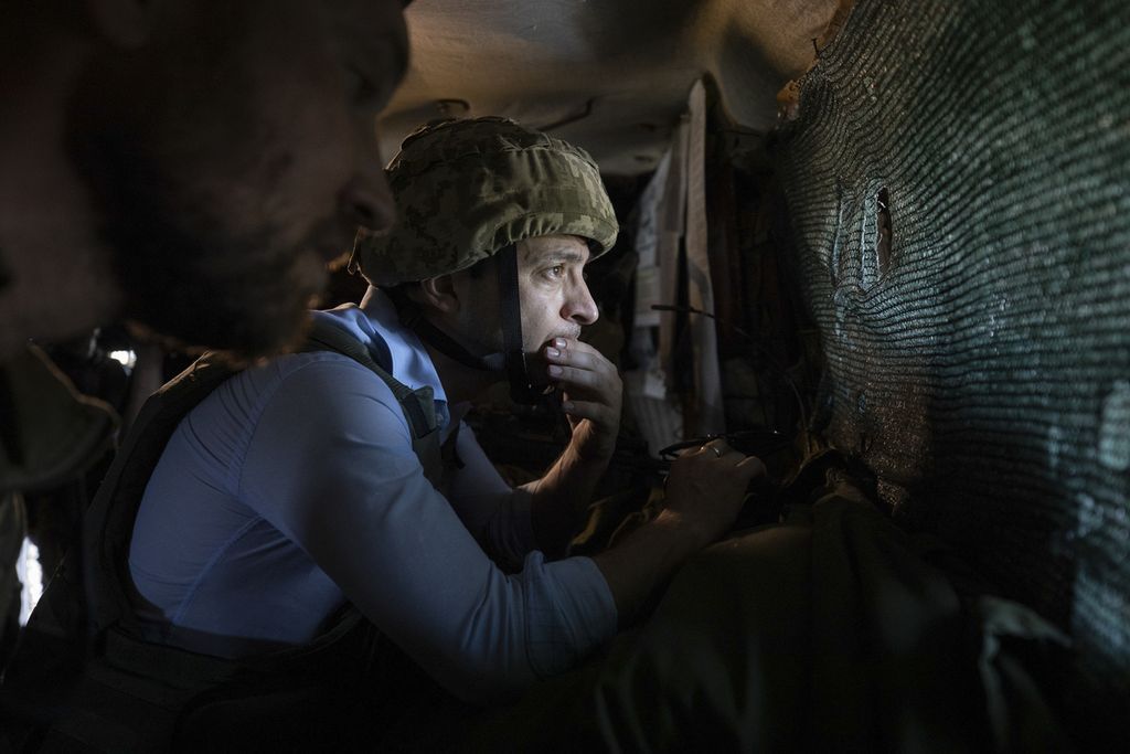 Presiden Ukraina Volodymyr Zelenskyy mengamati front pertempuran dari sebuah tempat perlindungan saat ia berkunjung ke wilayah Ukraina timur. 