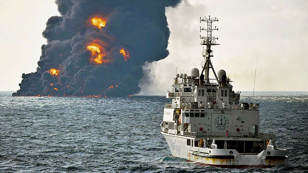 Foto  yang diambil oleh Kementerian Perhubungan China, Minggu (14/1), menunjukkan sebuah kapal penyelamat berlayar tak jauh dari tanker Iran, The Sanchi, yang tengah terbakar di   Laut China Timur. Api berkobar hebat membakar tanker itu. Ada kekhawatiran bocoran minyak akan mencemari  laut di kawasan perairan itu. 