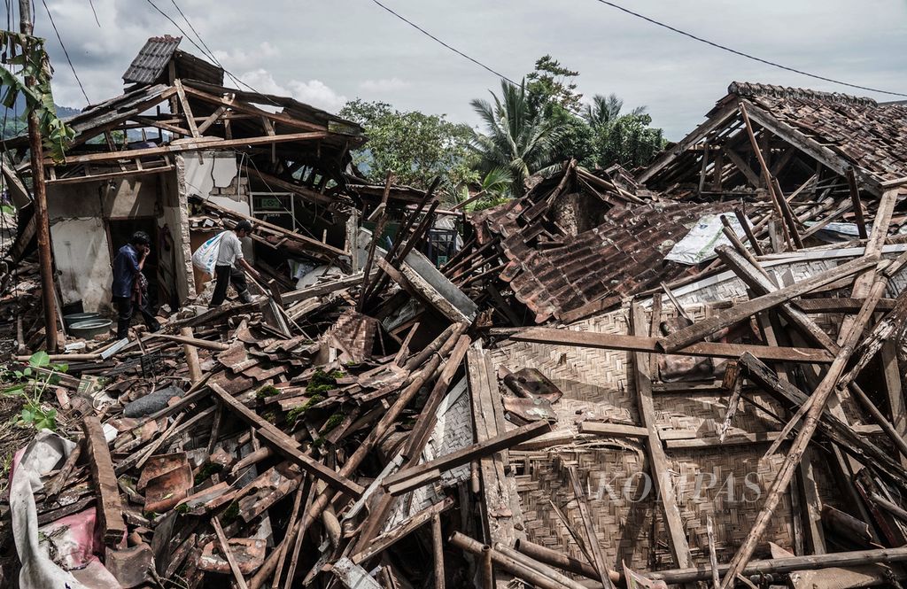 Warga melintasi reruntuhan rumah di RW 003 Kampung Sarampad, Cugenang, Kabupaten Cianjur, Jawa Barat, Minggu (27/11/2022). Situasi permukiman warga wilayah ini hampir seluruhnya mengalami rusak berat dan tidak bisa diperbaiki kembali. Kerusakan ini dipicu gempa M 5,6 yang berpusat di darat. 