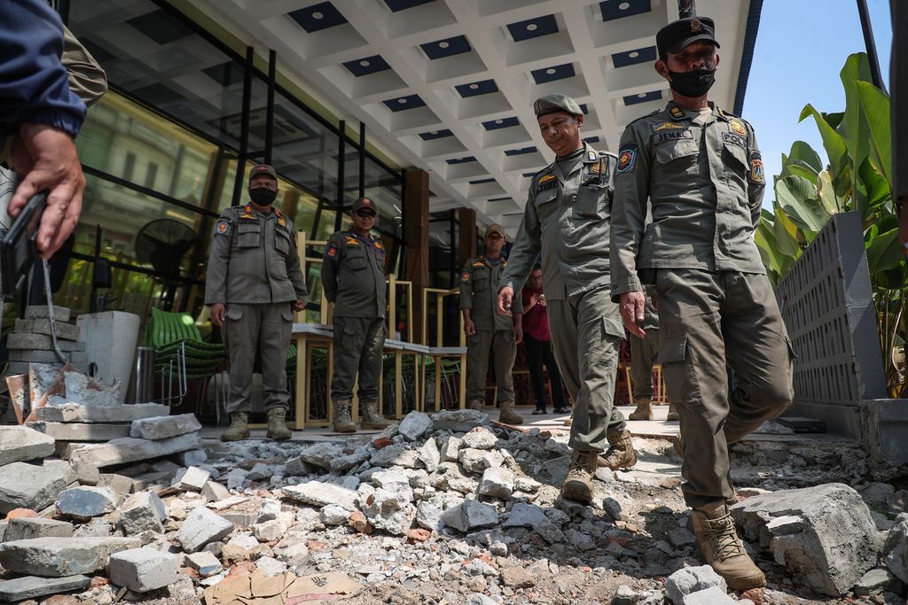 DKI Jakarta Civil Service Police Unit officers inspect the demolition of the front of several shophouses that violated the rules on Jalan Niaga, Pluit, Penjaringan, North Jakarta, Tuesday (23/5/2023).