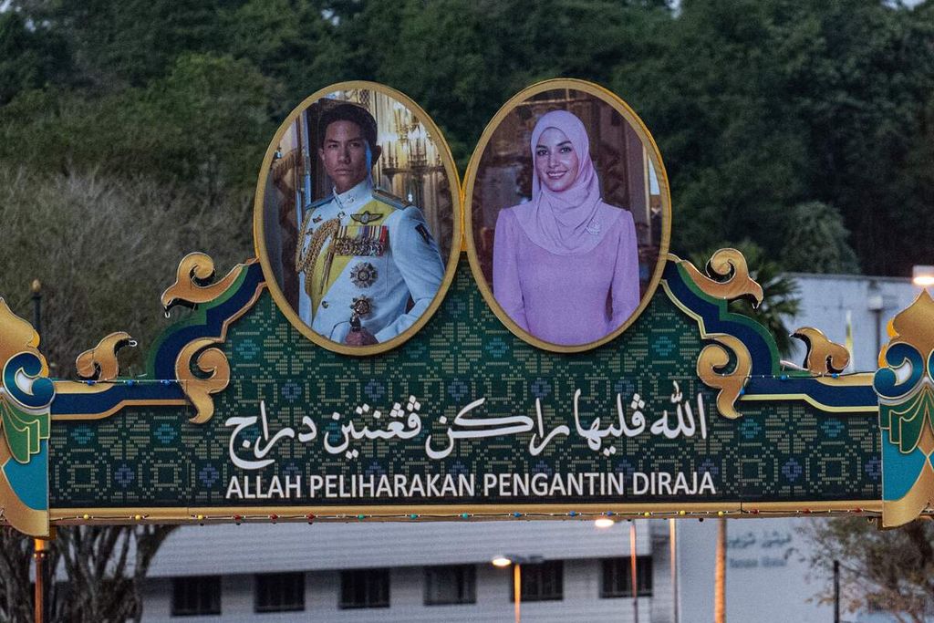 Foto mempelai pengantin, Pangeran Abdul Mateen (kiri) dan Anisha Rosnah (kanan), dengan pesan berisi doa dalam bahasa Melayu, terpampang di salah satu ruas jalan di Bandar Seri Begawan, Brunei Darussalam, Rabu (10/1/2024). 