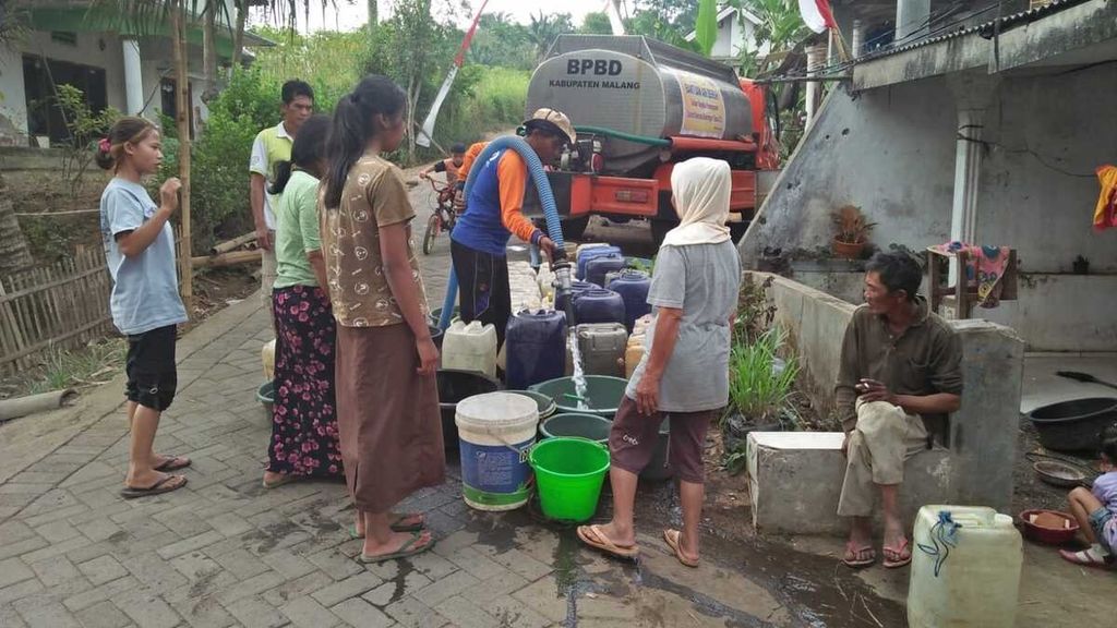 Petugas Badan Penanggulangan Bencana Daerah Kabupaten Malang, Jawa Timur, melakukan pengedropan air bersih kepada warga di Desa Klampok, Kecamatan Singosari, Minggu (10/9/2023).