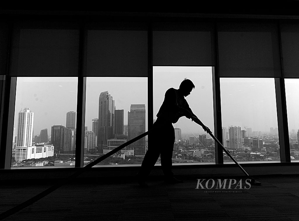 Pekerja membersihkan ruangan di sebuah perkantoran di kawasan Sudirman, Jakarta, beberapa waktu lalu.
