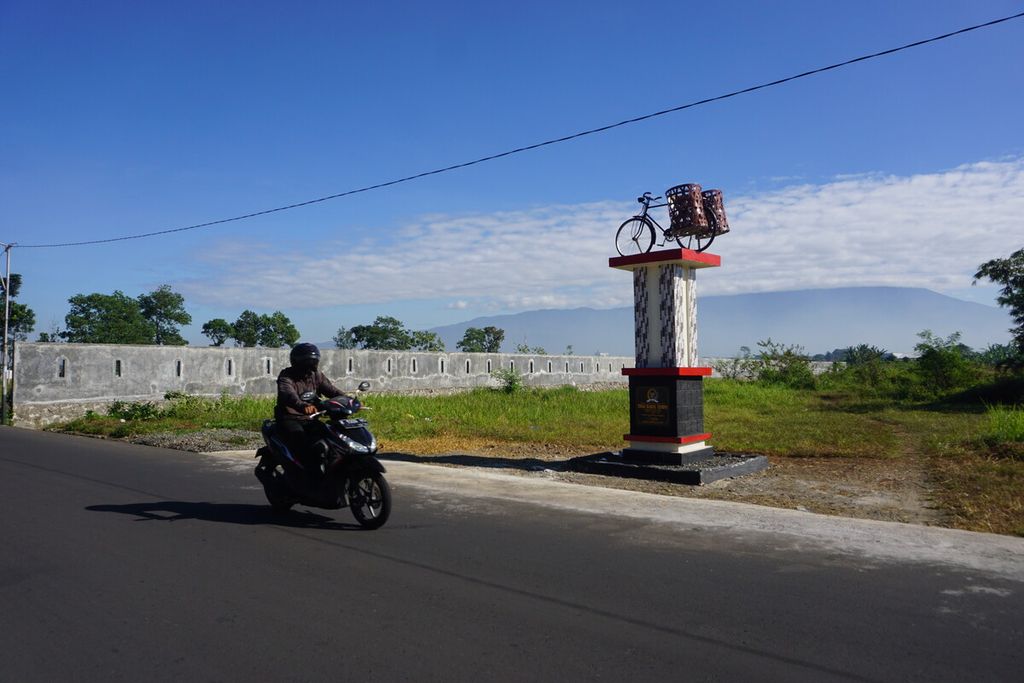 Pengendara melintas di depan Tugu Bakul Tempe di Desa Pliken, Kabupaten Banyumas, Jawa Tengah, Sabtu (9/7/2022).