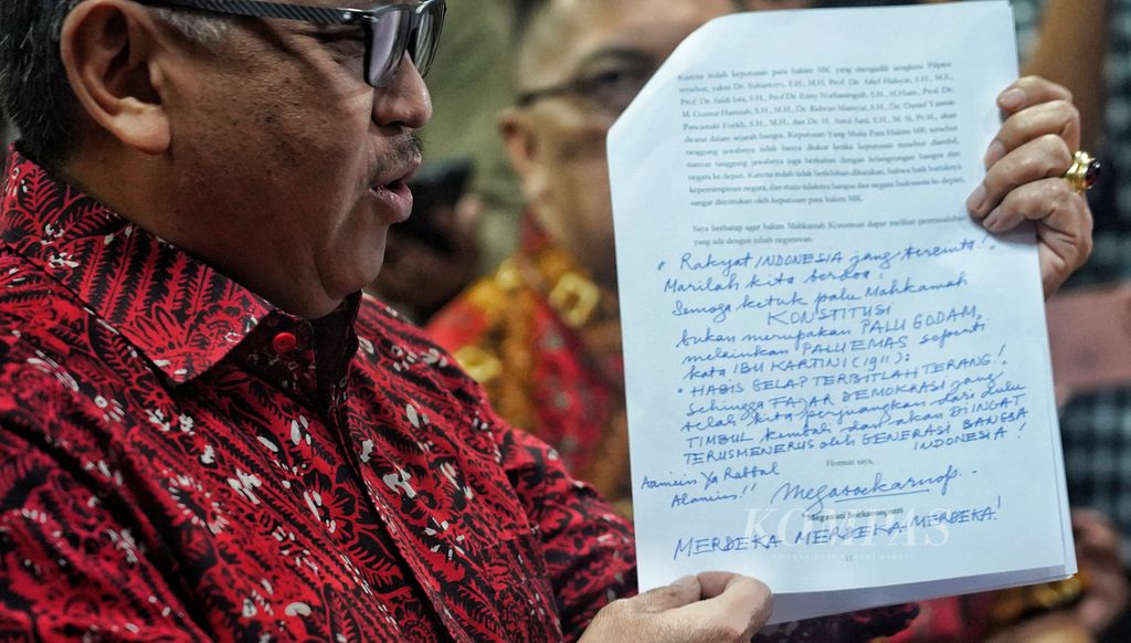 PDI-P Secretary General Hasto Kristiyanto shows the handwriting of PDI-P General Chair Megawati Soekarnoputri which was inscribed on the <i>amicus curiae</i> letter and submitted to the Constitutional Court, Jakarta, Tuesday (16/4/2024).