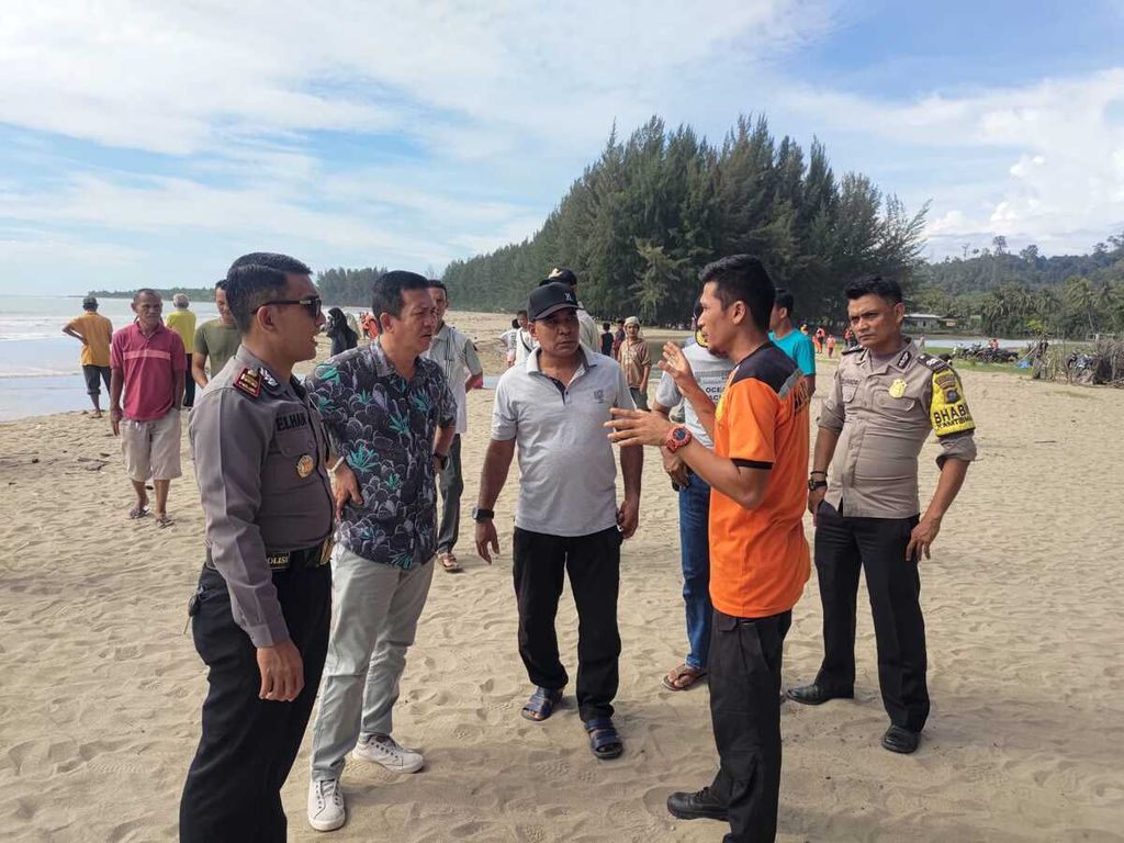 Para petugas berkoordinasi dalam upaya mencari Naira (12), siswa SD yang tenggelam saat berenag di Pantai Tan Sridano, Kelurahan Taluak, Kecamatan Batang Kapas, Pesisir Selatan, Sumatera Barat, Sabtu (17/12/2022).