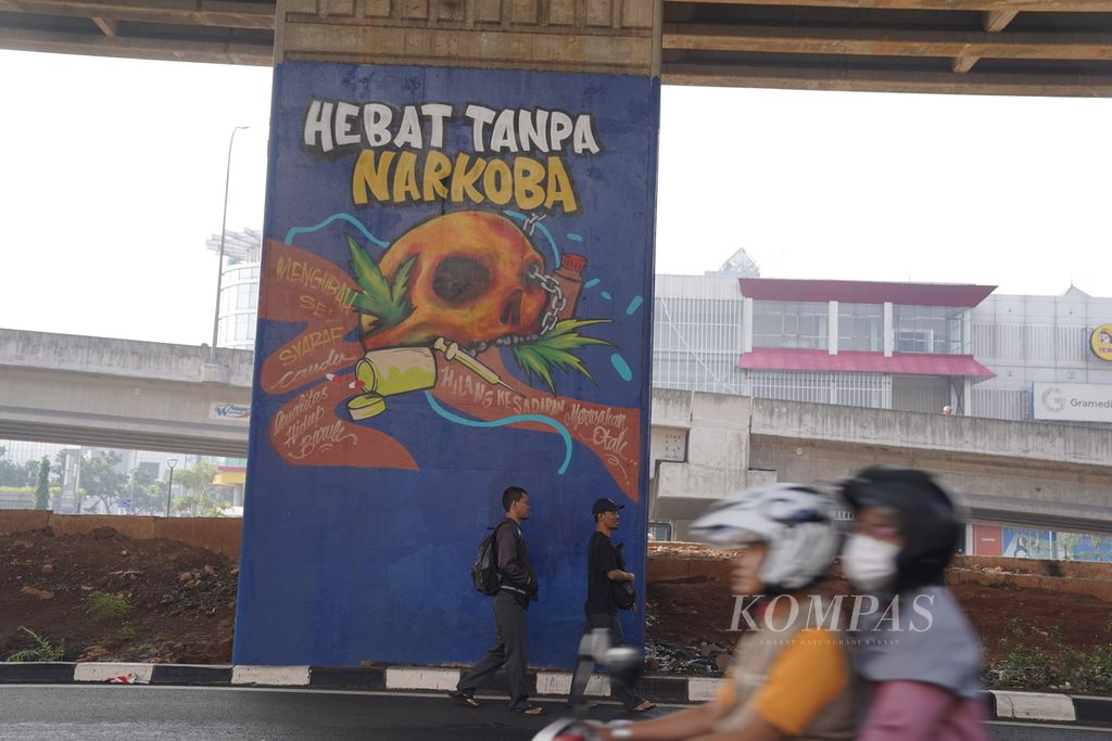 Warga melintasi mural ajakan untuk menjauhi narkoba di Jalan KH Noer Ali, Kota Bekasi, Jawa Barat, Minggu (7/1/2024). Selain berdampak buruk pada kesehatan hingga kematian, pengguna narkoba juga akan terjerat hukum. 