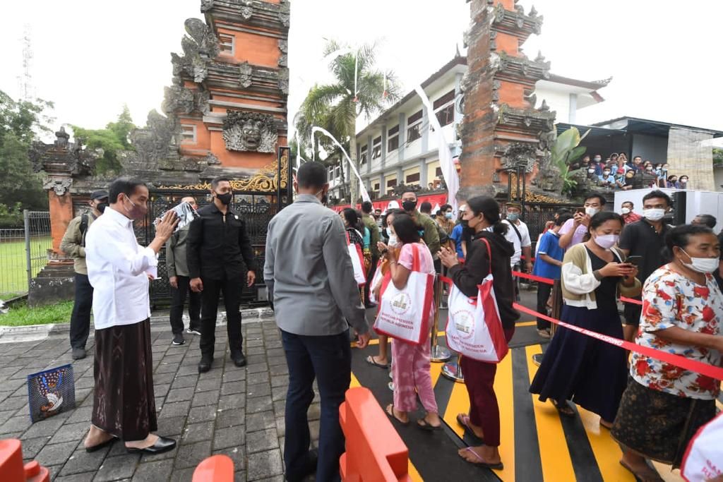Presiden Joko Widodo membagikan kebutuhan pokok di Istana Kepresidenan Tampaksiring, Kabupaten Gianyar, Kamis (5/5/2022). 