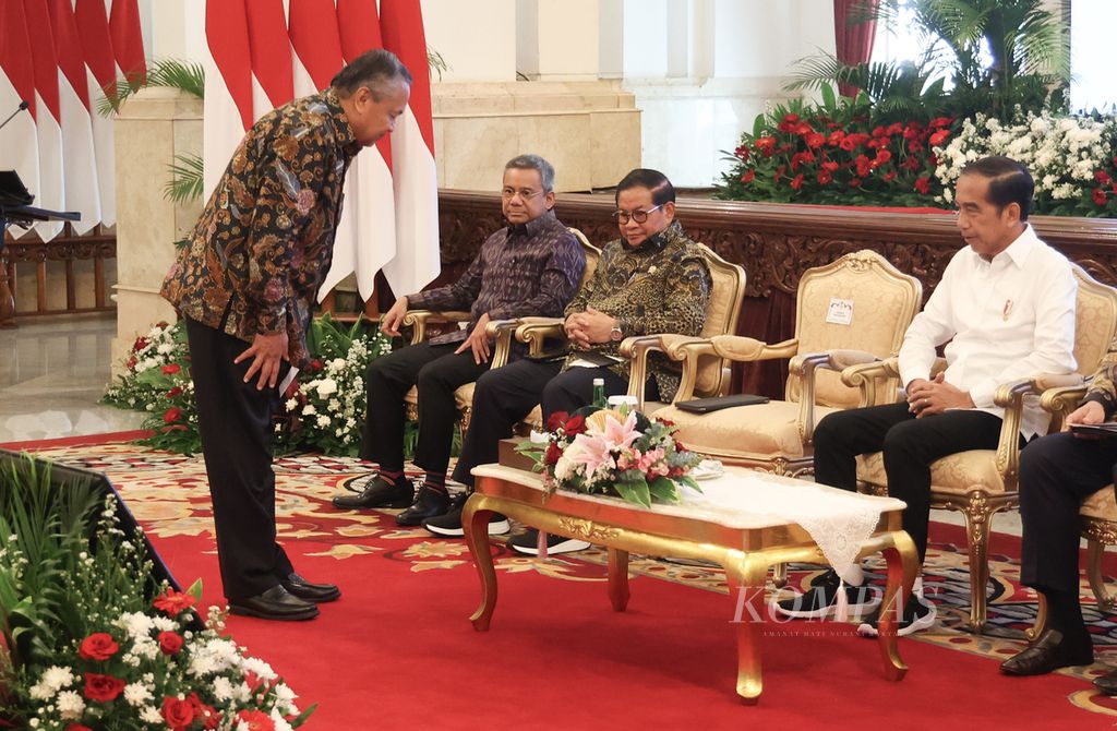 Gubernur Bank Indonesia Perry Warjiyo (kiri) memberi hormat kepada Presiden Joko Widodo saat akan memberikan laporan dalam rapat koordinasi pengendalian inflasi tahun 2024 dan tim pengendalian inflasi daerah award di Istana Negara, Jakarta, Jumat (14/6/2024).  