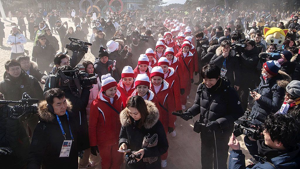Pemandu sorak asal Korea Utara dikelilingi oleh wartawan saat mereka menuju pantai Gyeongpo, di Gangneung, di sela-sela Olimpiade Musim Dingin PyeongChang, Korea Selatan, Selasa (13/2). Kehadiran delegasi Korut dalam Olimpiade menjadi pusat perhatian media. 