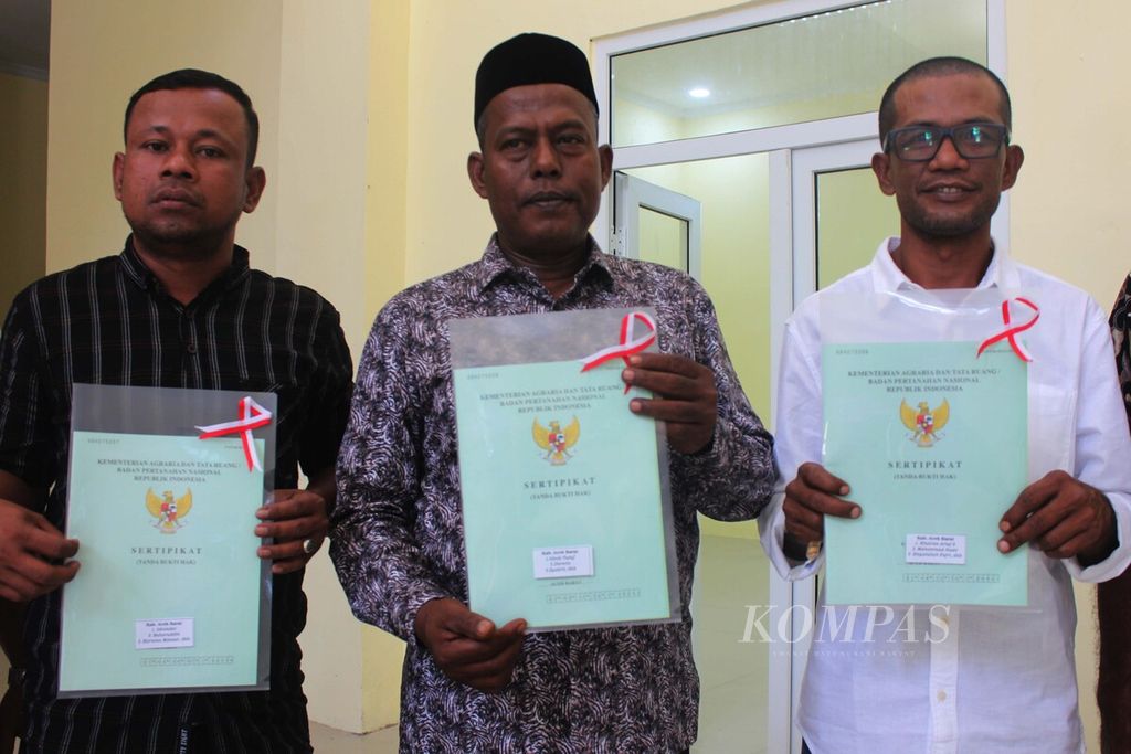 Eks kombatan Gerakan Aceh Merdeka dan korban konflik memperlihatkan sertifikat tanah yang diserahkan oleh pemerintah dalam perayaan 17 tahun perdamaian Aceh, Senin (15/8/2022).