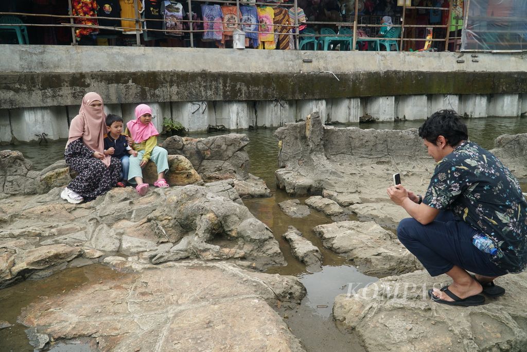 Wisatawan berfoto di obyek wisata batu Malin Kundang di kawasan Pantai Air Manis, Kota Padang, Sumatera Barat, Rabu (30/8/2023).