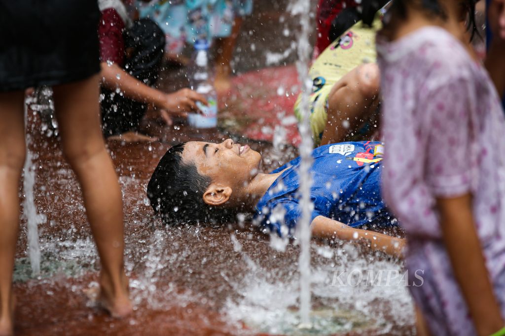 Anak-anak bermain air mancur yang menjadi salah satu daya tarik Taman Puring di Kebayoran Baru, Jakarta Selatan, Rabu (1/5/2024). 