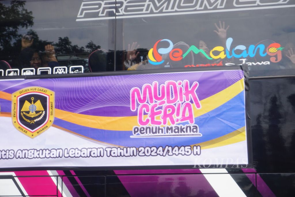 Peserta mudik gratis melambaikan tangan dari bus saat keberangkatan dari Terminal Bulupitu, Purwokerto, Banyumas, Jawa Tengah, Senin (15/4/2024). 