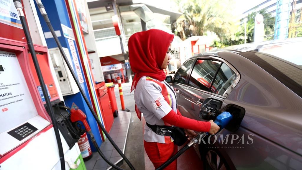 Petugas melayani pengisian bahan bakar minyak (BBM) jenis pertamax di SPBU 31.129.02 di kawasan Kuningan, Jakarta, Senin (2/7/2018).