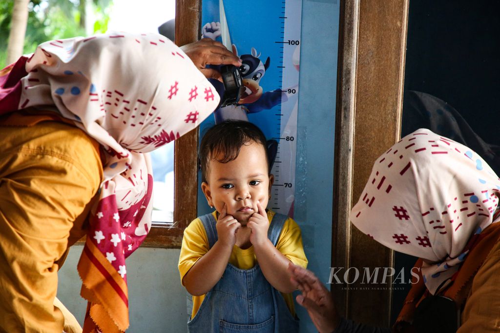 Kader posyandu mengukur tinggi badan seorang anak di Posyandu Mawar, Larangan Selatan, Larangan, Kota Tangerang, Banten, Jumat (10/3/2023).