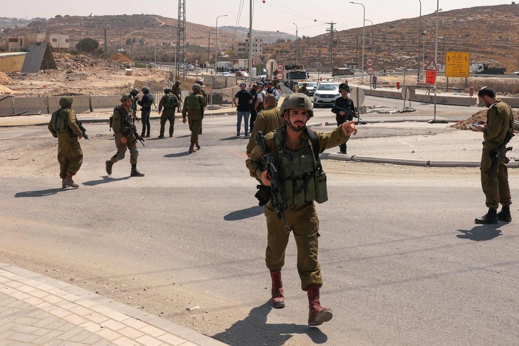 Pasukan keamanan Israel memblokade satu ruas jalan menuju lokasi yang dilaporkan terjadi serangan di Hebron selatan, wilayah pendudukan Tepi Barat, Senin, 21 Agustus 2023. 