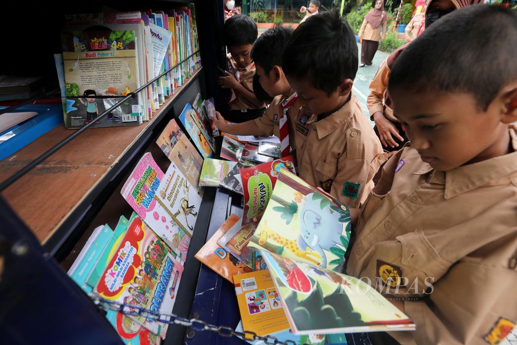 Anak-anak membaca buku yang dibawa motor layanan perpustakaan keliling Sudin Perpustakaan dan Kearsipan (Sudin Pusip) di SDN 04 Pondok Bambu, Jakarta, Rabu (26/10/2022). 