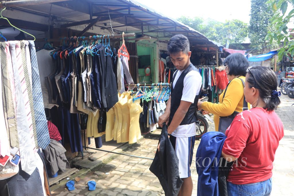 Pembeli mencoba rompi bekas di Pasar Simalingkar, Medan, Sumatera Utara, Rabu (22/3/2023).