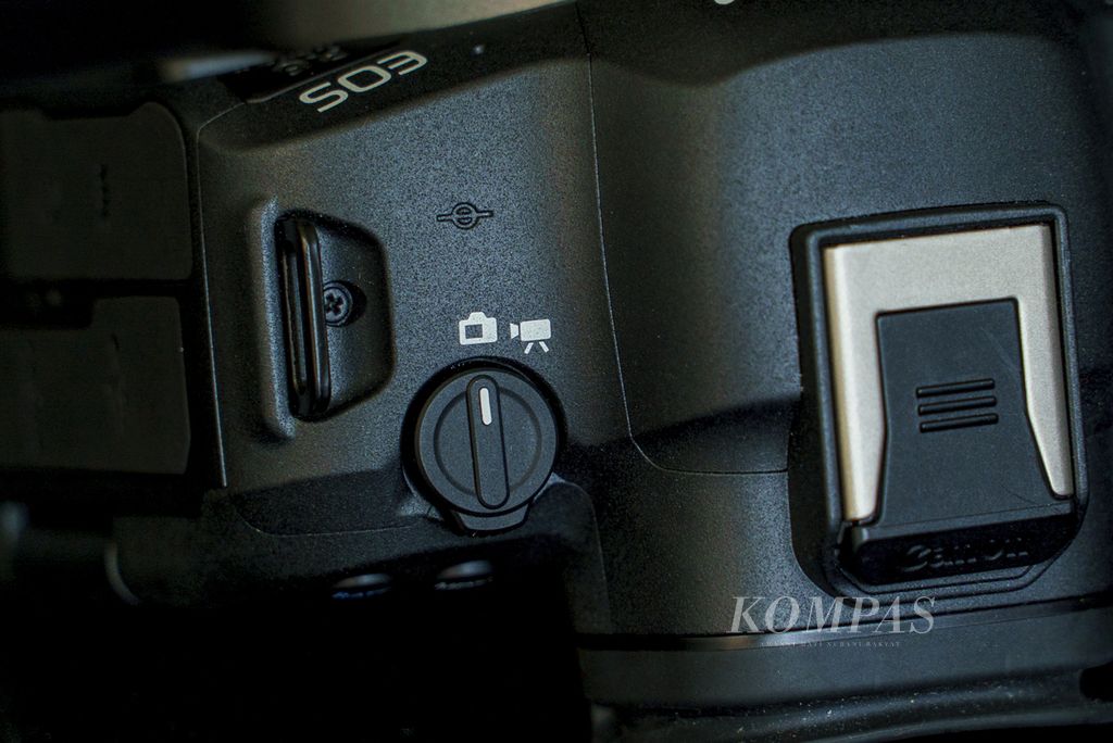 Pada bagian kiri atas bodi kamera Canon R6 Mark II terdapat tombol pilihan untuk merekam video dan foto. 