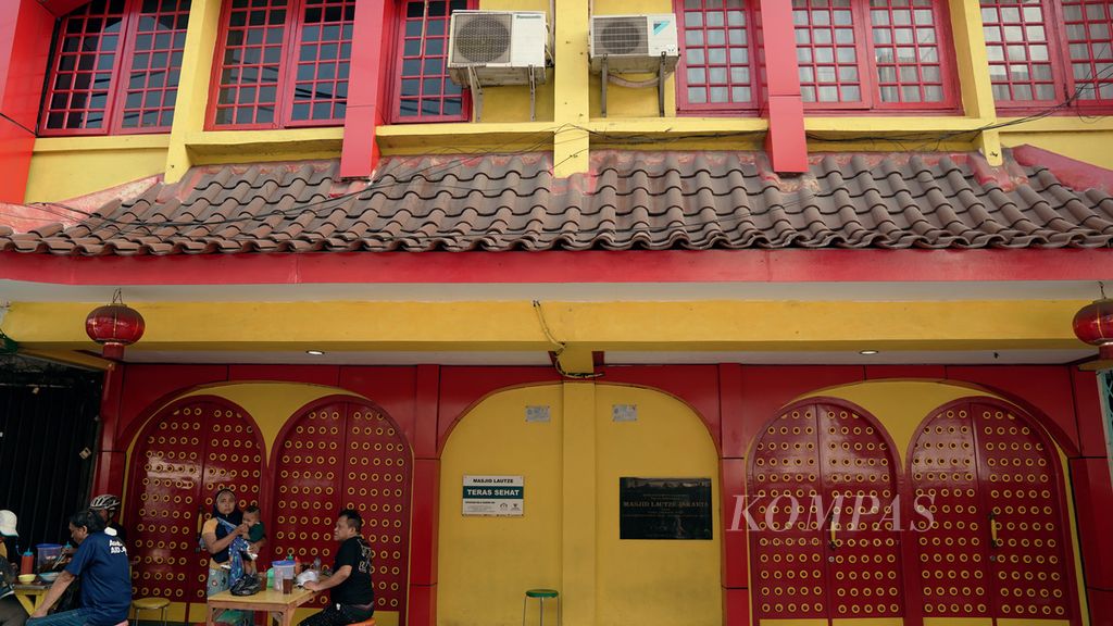 Warga menikmati mi di depan Masjid Lautze dalam acara Hajatan Multietnis Sawah Besar di Jalan Lautze Raya, Sawah Besar, Jakarta Pusat, Minggu (24/7/2022). Masjid dengan warna mencolok, merah, kuning, dan hijau, tersebut mulai berfungsi sebagai masjid sejak tahun 1991.
