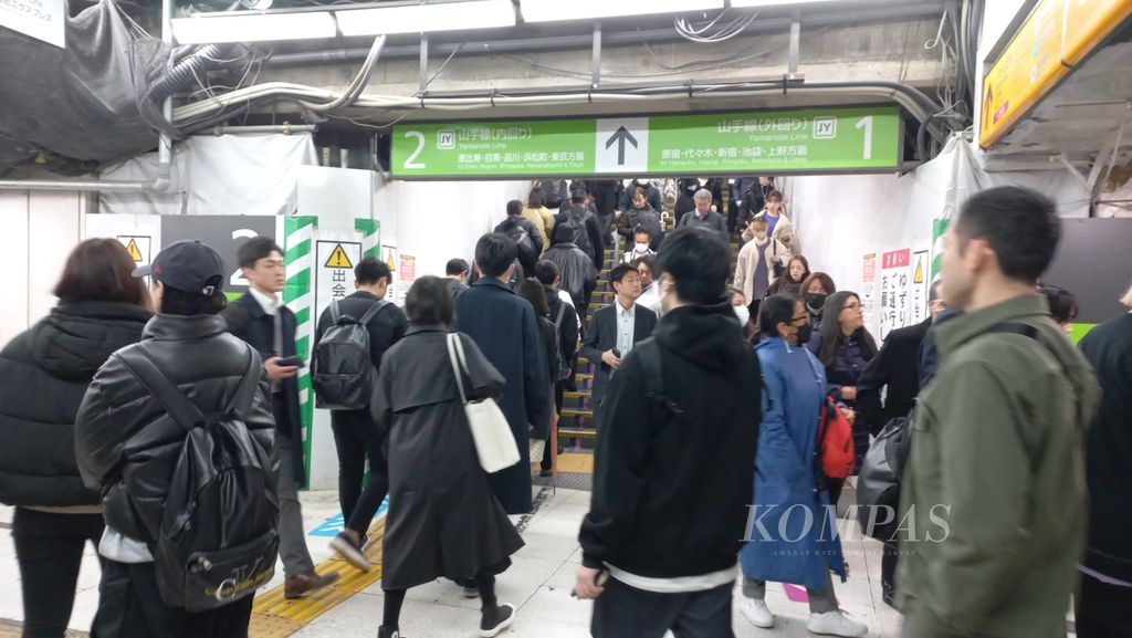 Penumpang di Stasiun Shibuya, Tokyo, Jepang, memasuki peron dengan mengikuti tanda dan warna dari lintasan pelayanan dari operator kereta, Rabu (15/11/2023).