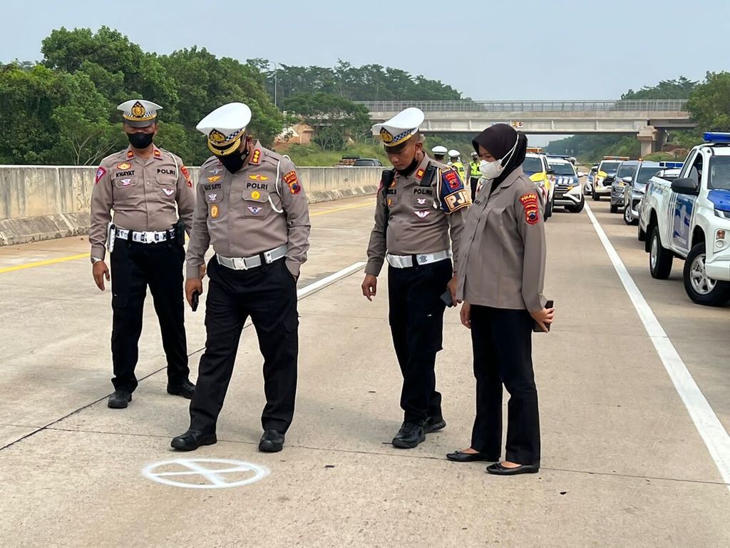 Polisi mengecek kondisi tempat kejadian perkara kecelakaan tabrak belakang di Jalan Tol Semarang-Batang, Jawa Tengah, Senin (5/9/2022). Dalam kecelakaan tersebut, tujuh orang meninggal dan enam orang luka-luka.
