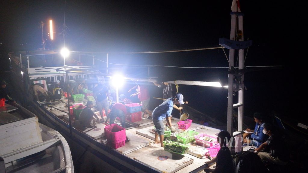Nelayan dan pedagang ikan melakukan bongkar muat ikan laut di Pelabuhan Perikanan Banjarmasin, Kalimantan Selatan, Jumat (24/6/2022) malam. 