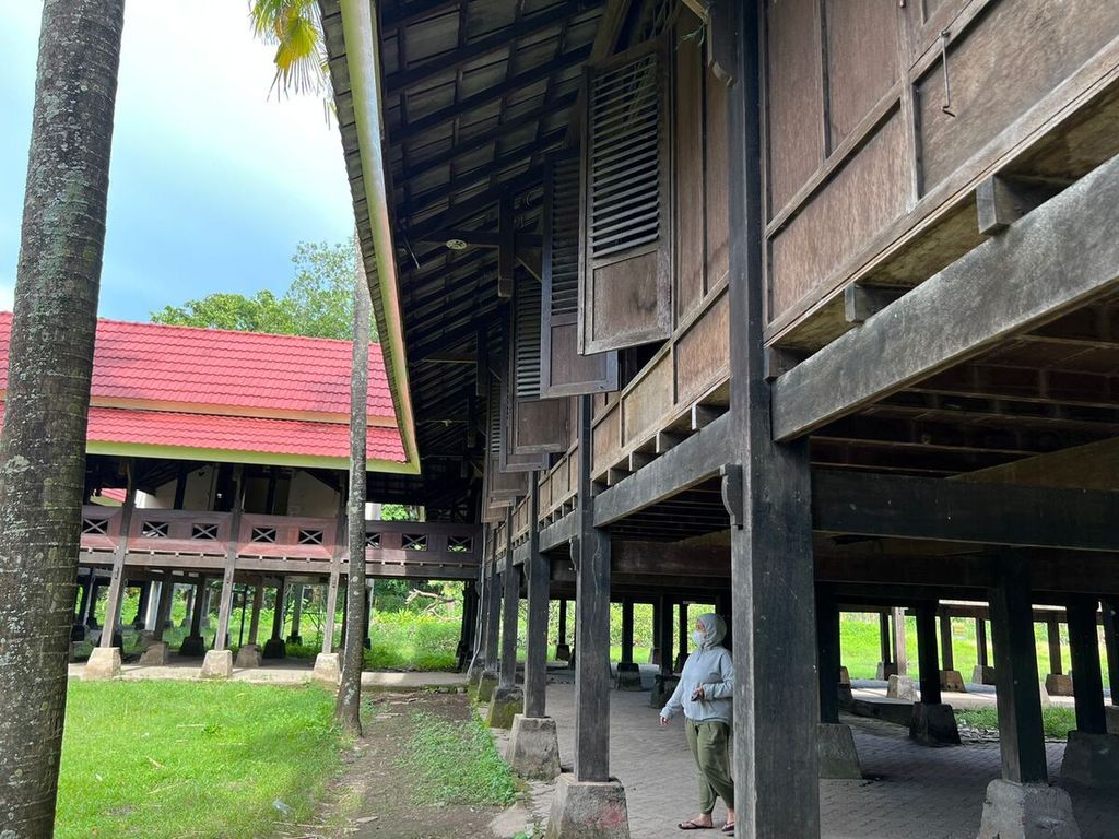 Seorang pengunjung berjalan di antara tiang-tiang rumah panggung di kawasan Benteng Somba Opu, Gowa, Kamis (24/3/2022).