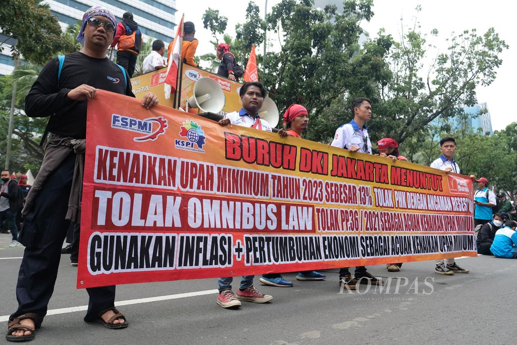 Pengunjuk rasa membentangkan spanduk berisikan penolakan kenaikan upah minimum provinsi (UMP) yang sebesar 5,6 persen di depan Balai Kota DKI Jakarta, Jakarta Pusat, Jumat (2/12/2022). Mereka meminta kenaikan UMP menjadi 10,55 persen. 